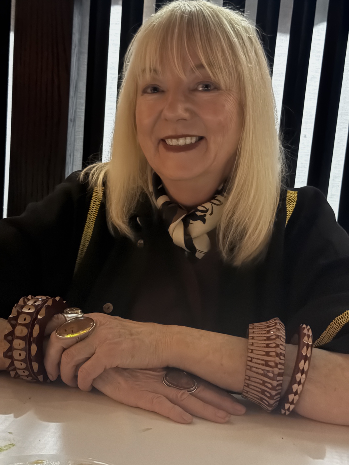 Annie Kelly wearing a patterned scarf and sculptural wooden jewellery