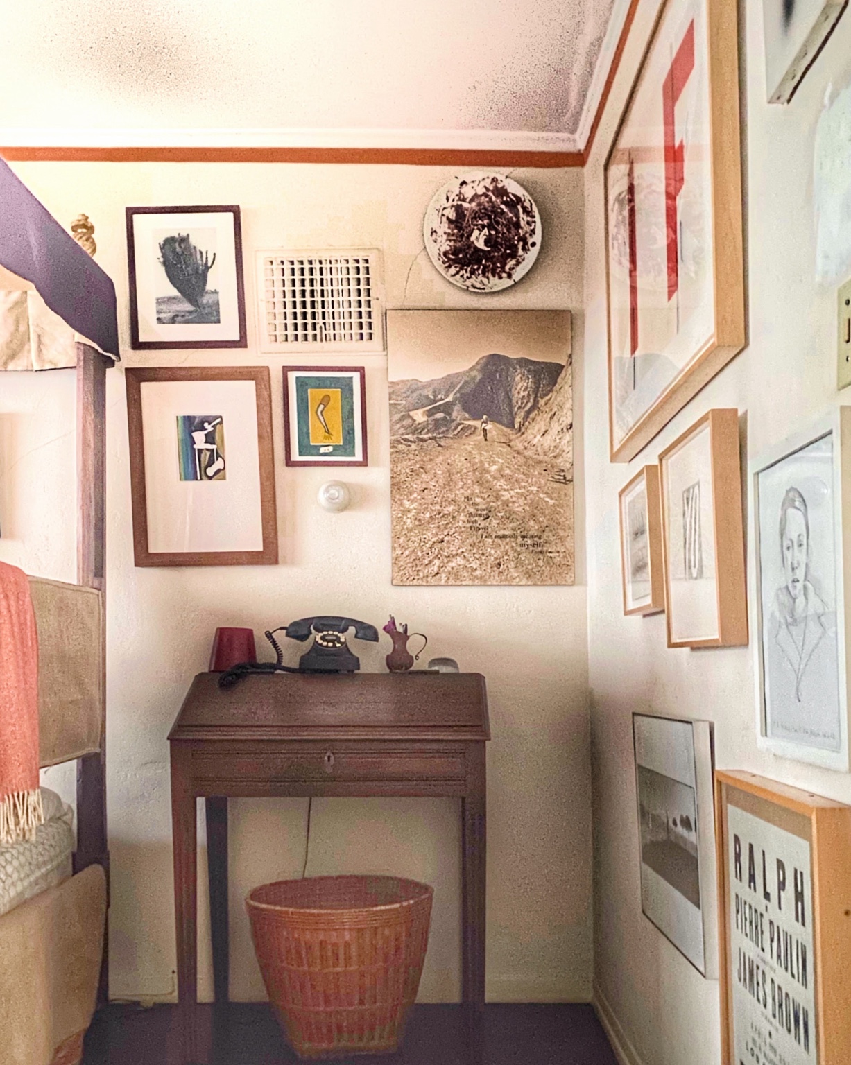 An intimate room with an eclectic gallery wall, a writing desk, and collected objects