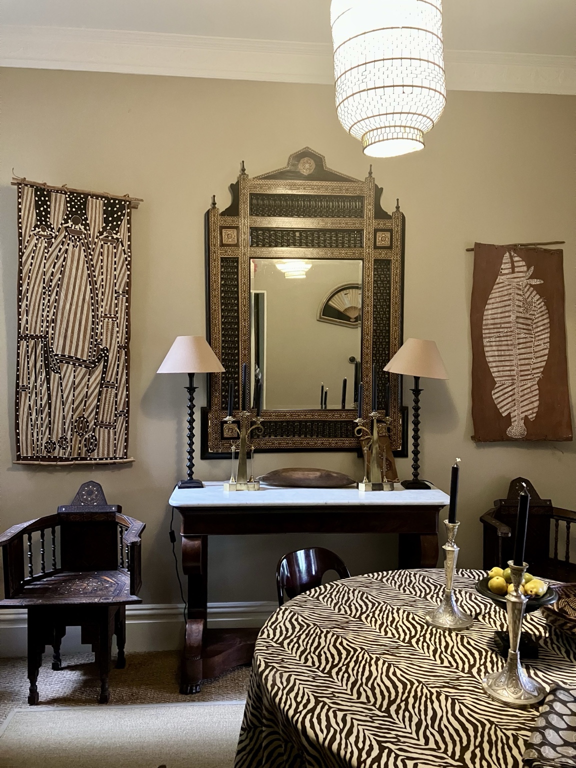 Paddington house interior with bark artworks, an ornate mirror, collected objects and a patterned tablecloth